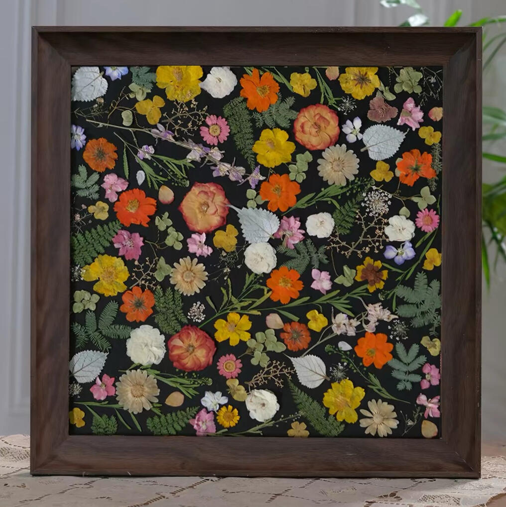 Custom pressed flower artwork frame with botanical composition on dark background
